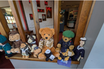 Teddy bears dressed in different armed forces uniforms.