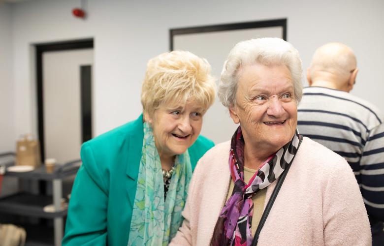 Two elderly women having a giggle together